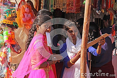 India, Hampi, 02 February 2018. Young girls in bright pink saris are buying something on the market Editorial Stock Photo