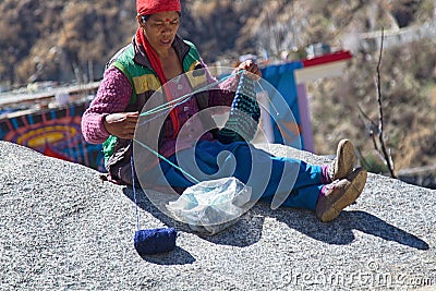 Indian mountaineer woman knits on winter day sitting in sun Editorial Stock Photo