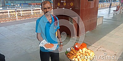 india street food vendor offering traditional sweet at railway station Editorial Stock Photo