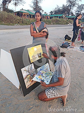 Indian artist draws hi pictures in Arambol beach by the evening. Goa, India Editorial Stock Photo
