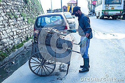 Indian Asian Garbage man collecting garbage in the garbage cart. Concept about Editorial Stock Photo