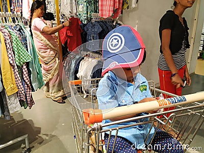 Indian Blue Shirt Wear little Kid in a Big Bazaar Sitting in a Trolley with Cap Editorial Stock Photo