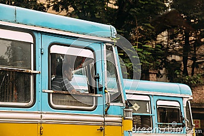 Indian Blue and Yellow Bus color Driver waiting for green traffic light on the road in Kolkata, India Editorial Stock Photo