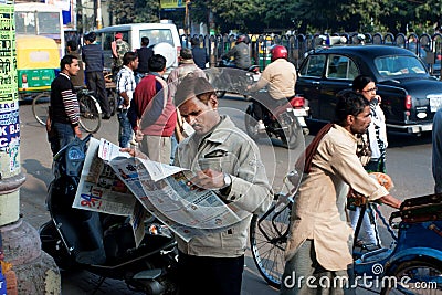 Indian businessman reads a newspaper in the crowd Editorial Stock Photo