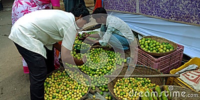 indian buyer picking up fresh lemon from the street village store Editorial Stock Photo