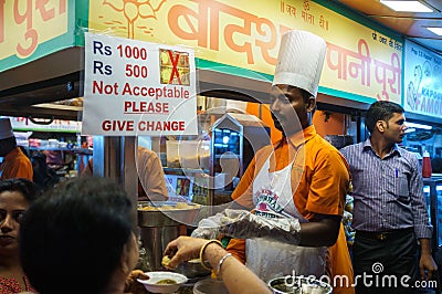 Indian cook preparing street food at the stall in Mumbai at night Editorial Stock Photo
