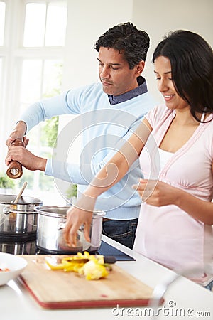 Indian Couple Cooking Meal At Home Stock Photo