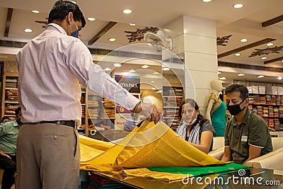 An Indian couple shopping for a saree, wearing a face mask in the Corona epidemic. Editorial Stock Photo