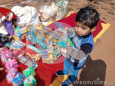 an indian cute little boy picking toys from street shop during fair program in India January 2020 Editorial Stock Photo