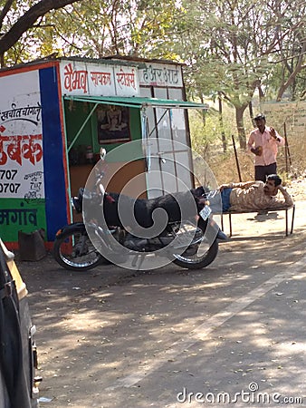 Indian reparing shop with sleeping man Editorial Stock Photo