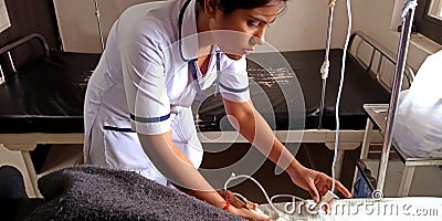 an indian female nurse staff injecting glucose bottle to the patient at hospital ward in india aug 2019 Editorial Stock Photo
