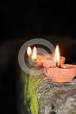  Diwali. Festival of light. three lamp line on the wall with blurred background. Indian winter season festival. Stock Photo