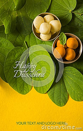 Indian festival dussehra, showing golden leaf with traditional indian sweets pedha in silver bowl on yellow background, greeting c Stock Photo