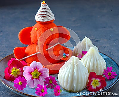 Eco friendly Idol of lord Ganesha with modak sweet and flowers Stock Photo