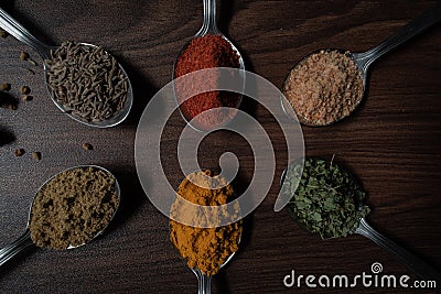Indian Garam masala powder in bowl and it`s ingredients colourful spices. Served over moody background. selective focus Stock Photo