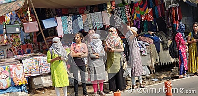 Indian girls covering their face with a cloth waiting for bus after doing shopping at Koti, Hyderabad, Telangana.. Editorial Stock Photo