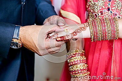 Indian groom putting ring on indian bride Stock Photo