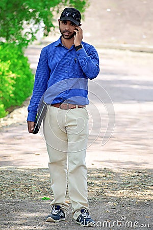 Handsome Businessman calling on cell with laptop in outdoor Stock Photo