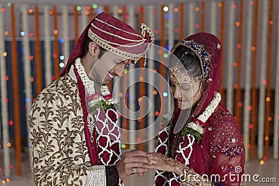 Indian Hindu Bride & Groom a happy smiling couple exchanging wedding ring. Stock Photo