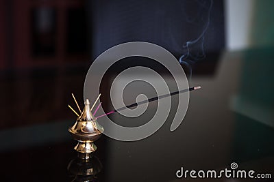 Indian incense sticks smoke in a Golden stand. Stock Photo