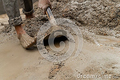 Indian labour mixing cement using shovel Stock Photo