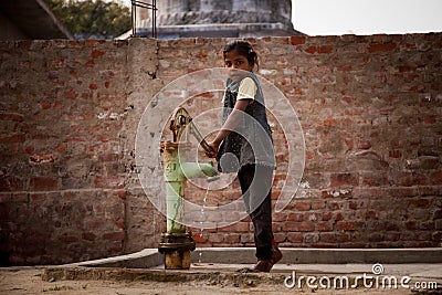 Indian little girl on hand-pump Editorial Stock Photo