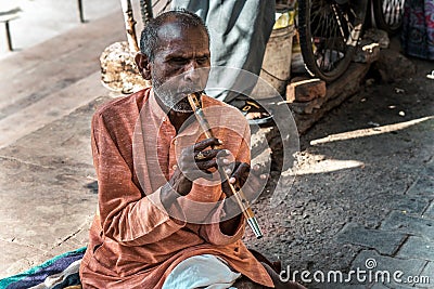 Indian man beggar playing a musical instrument Editorial Stock Photo