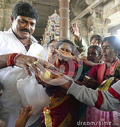 Indian man gives laddu treats to pilgrims Editorial Stock Photo