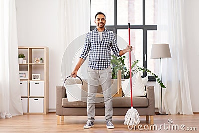 Indian man with mop and bucket cleaning at home Stock Photo