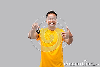 Indian Man Smilling Showing Thumb up and Car Keys Isolated. Driver Stock Photo