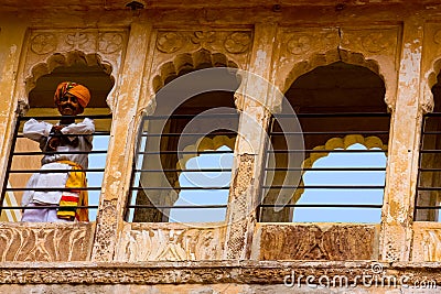 Jodhpur, India - August 20, 2009: Indian man with turban looking out of a window of the fort of Jodhpur, India Editorial Stock Photo