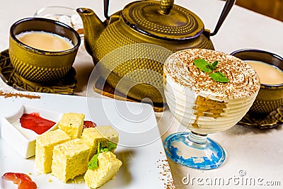 Indian masala chai, spiced tea with milk. Teapot and sweets Stock Photo