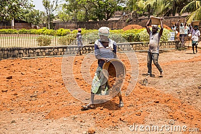 Indian men at work with seal to move the orange earth to cultivate food vegetables grass Editorial Stock Photo