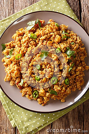 Indian minced chicken Bhuna Keema roasted with spices, tomatoes, chili peppers and onions close-up on a plate. Vertical top view Stock Photo