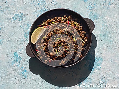 Indian minced meat Qeema on a sunny blue table. Stock Photo