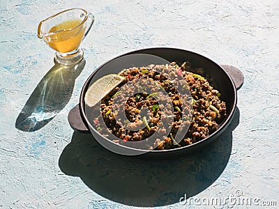 Indian minced meat Qeema on a sunny blue table. Stock Photo