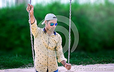 Indian Model standing in park holding swing chain Stock Photo