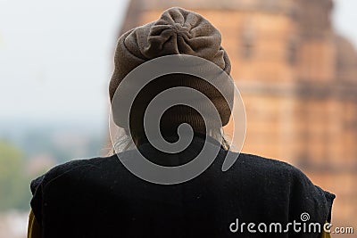 Indian person looking at temple, rear view, India. Editorial Stock Photo