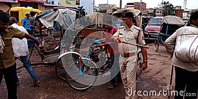 Indian police officer clearing terrific at outside railway station Editorial Stock Photo