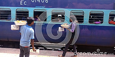 Indian railway food vendor selling samosa in front of train Editorial Stock Photo