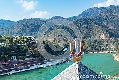 Indian religious symbol trishul with mountain and blue sky background Stock Photo