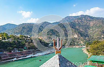 Indian religious symbol trishul with mountain and blue sky background Stock Photo