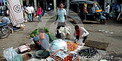 Indian retail greengrocer selecting vegetable lot from wholesale market place Editorial Stock Photo