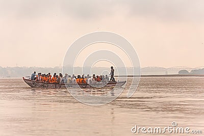 Indian rower man training his orange cloth rower men on the boat that floating over the Ganges Ganga river in Varanasi. Editorial Stock Photo