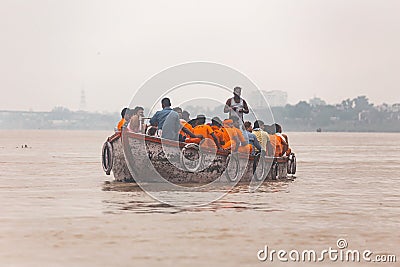 Indian rower man training his orange cloth rower men on the boat that floating over the Ganges Ganga river in Varanasi. Editorial Stock Photo