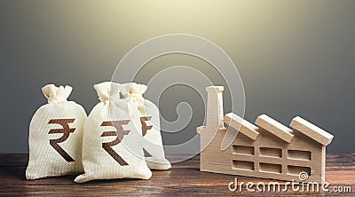 Indian rupee money bags and industrial factory plant. Privatization and purchase of industrial complexes. Investment Stock Photo