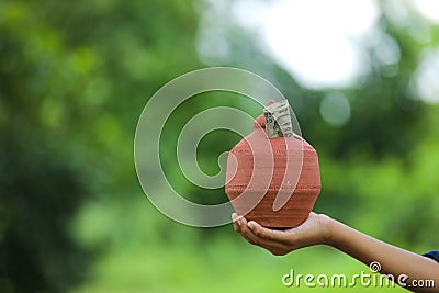 Indian rupees symbol and clay piggy bank Stock Photo