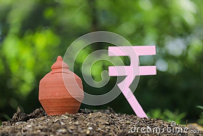 Indian rupees symbol and clay piggy bank Stock Photo