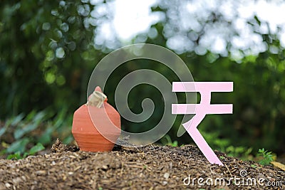 Indian rupees symbol and clay piggy bank Stock Photo
