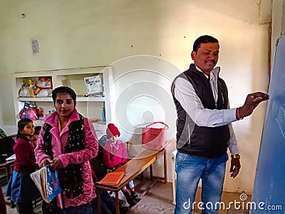 an indian school class teacher writing on chalkboard during class in india January 2020 Editorial Stock Photo